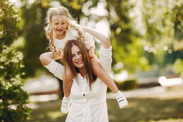 Mother with little daughter playing in a summer park