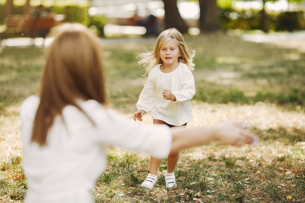 夏の公園で遊ぶ幼い娘を持つ母