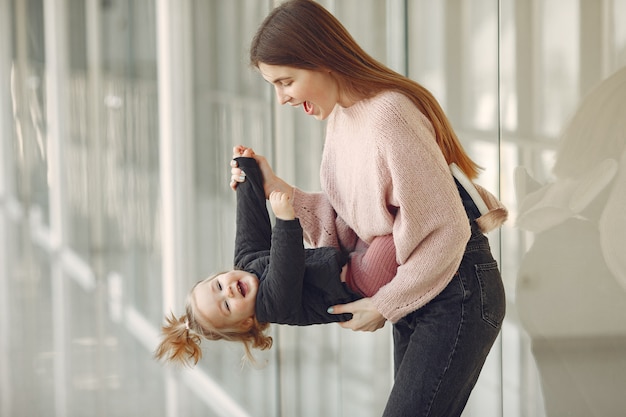 ホールに立っている小さな娘を持つ母