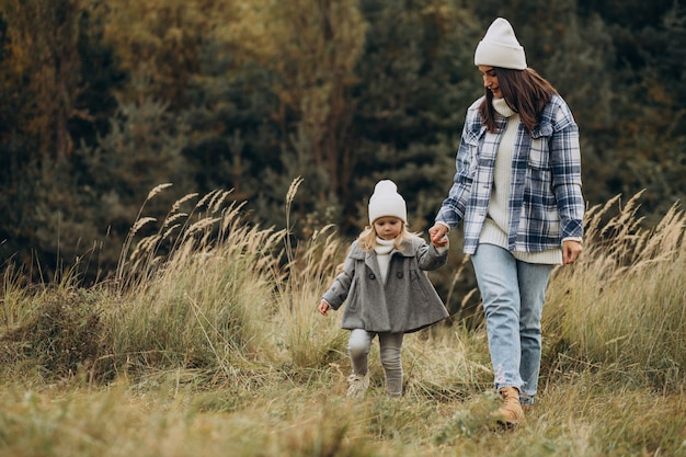 Mother with little daughter together in autumnal weather having fun