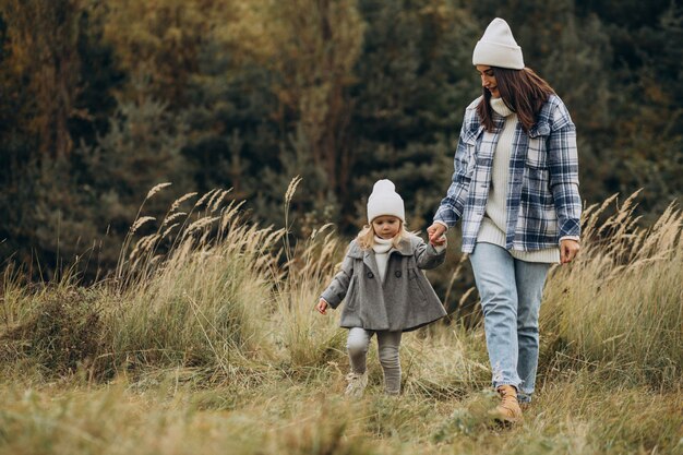 Mother with little daughter together in autumnal weather having fun