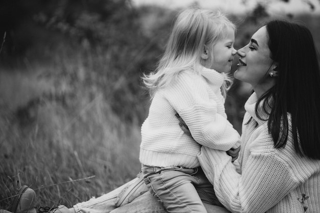 Mother with little daughter together in autumnal weather having fun