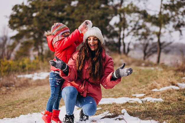 Mother with little daughter in a winter forest