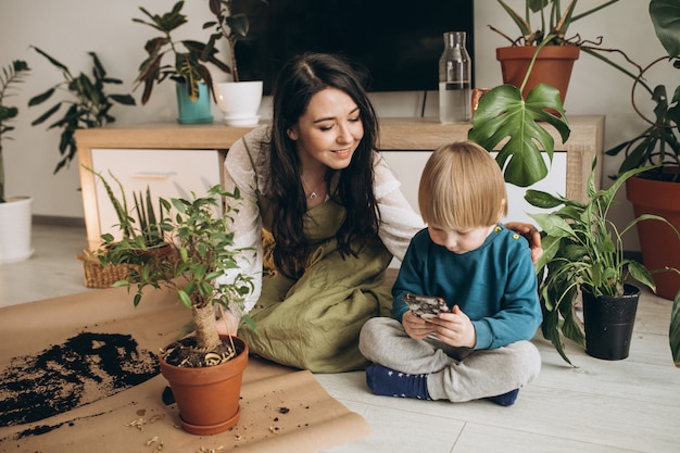 無料写真 自宅で植物を栽培する幼い息子を持つ母