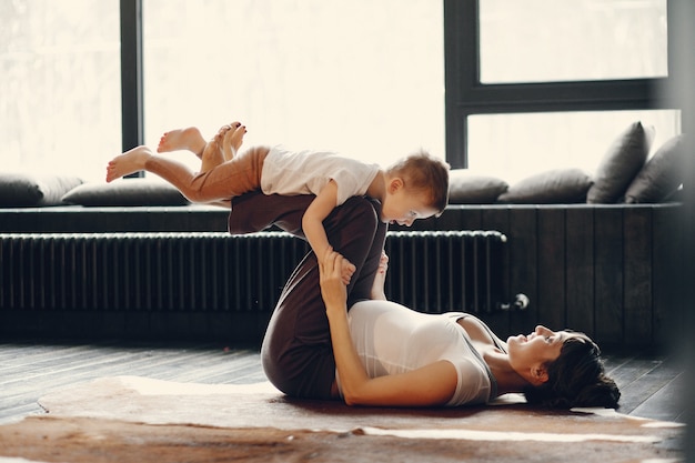 Mother with little son doing yoga at home