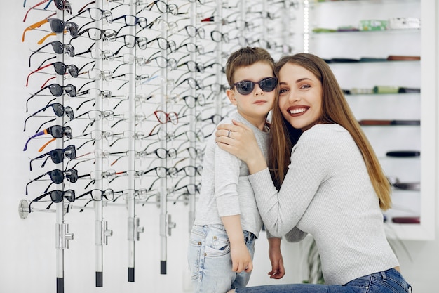 Mother with little son in the glasses store