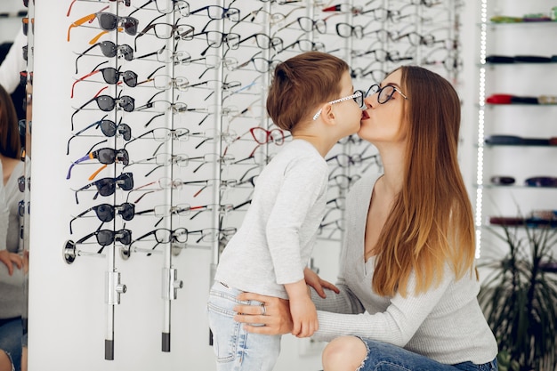 Mother with little son in the glasses store