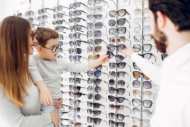 Mother with little son in the glasses store