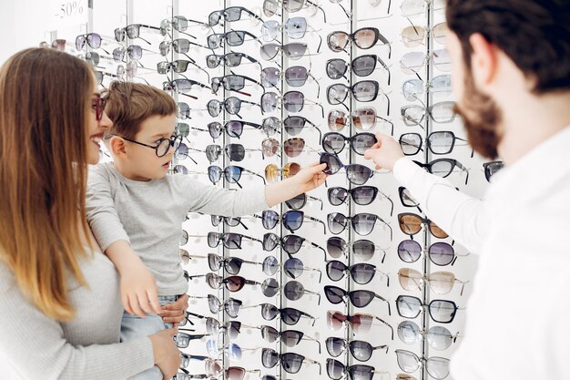 Mother with little son in the glasses store