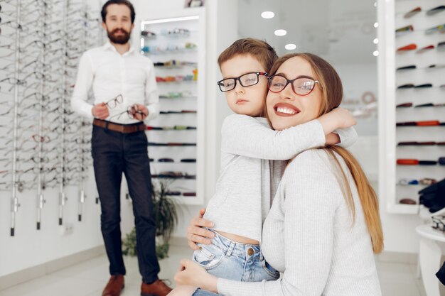 Mother with little son in the glasses store