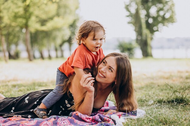 Mother with little son in park lying on blanket