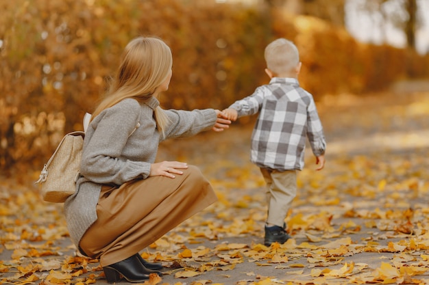 Mother with little son playing in a autumn field