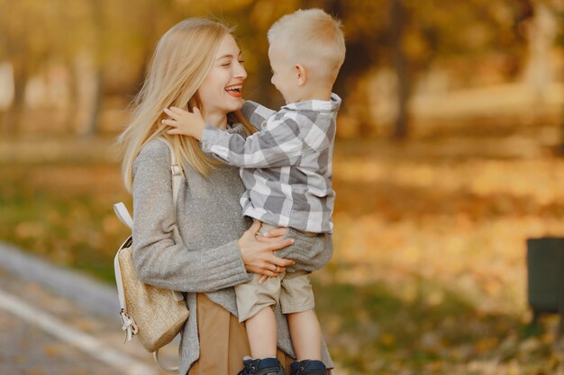 Mother with little son playing in a autumn field