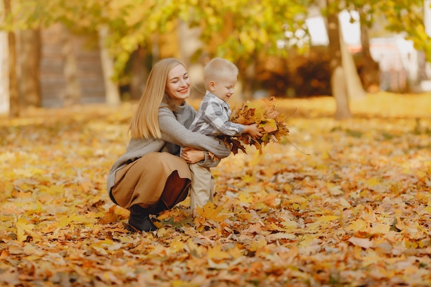 Free photo mother with little son playing in a autumn field