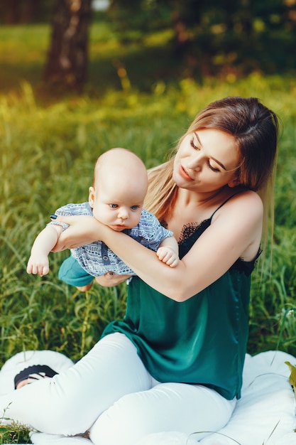 Mother with little son playing in a summer park