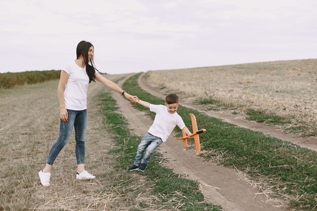 Mother with little son playing with toy plane