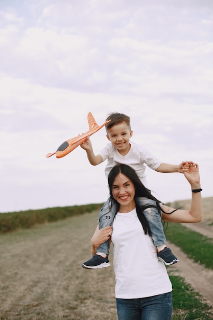 Mother with little son playing with toy plane