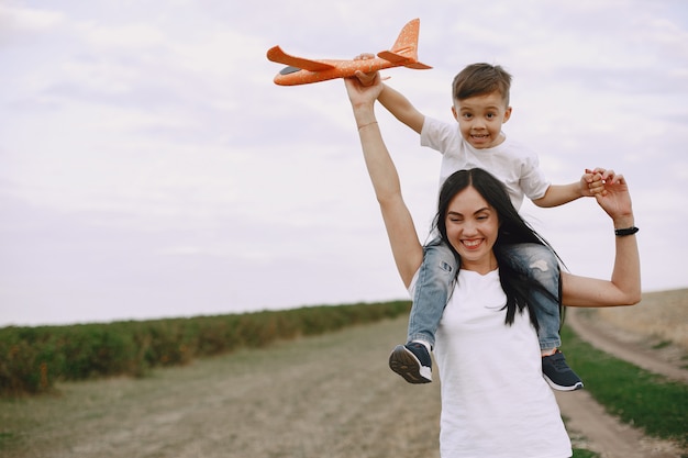 Mother with little son playing with toy plane