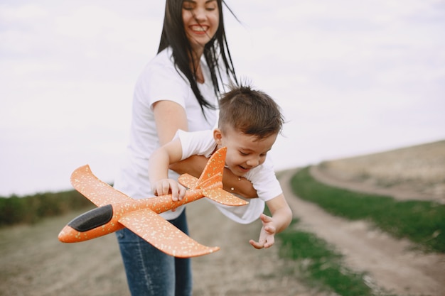 おもちゃの飛行機で遊んでの幼い息子を持つ母