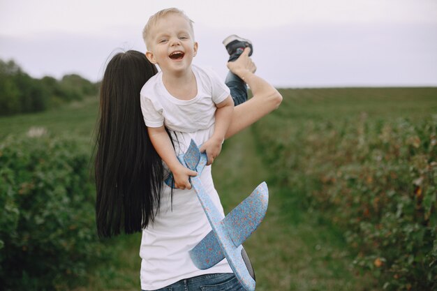 Mother with little son playing with toy plane