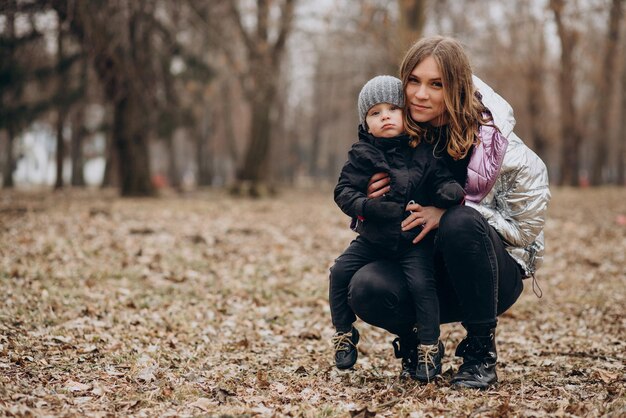 Mother with little son together in autumn park