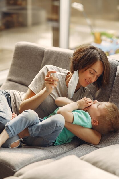 検疫で自宅で座っている小さな息子を持つ母