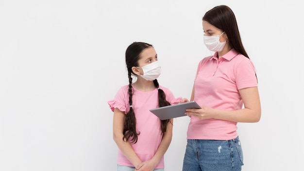 Mother with mask holding tablet