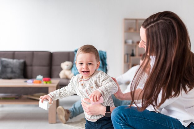 Mother with smiley baby at home