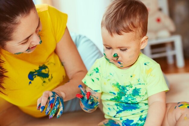 The mother with son painting a big paper with their hands