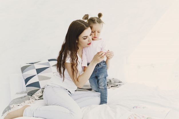 Mother with thermometer is sitting near daughter