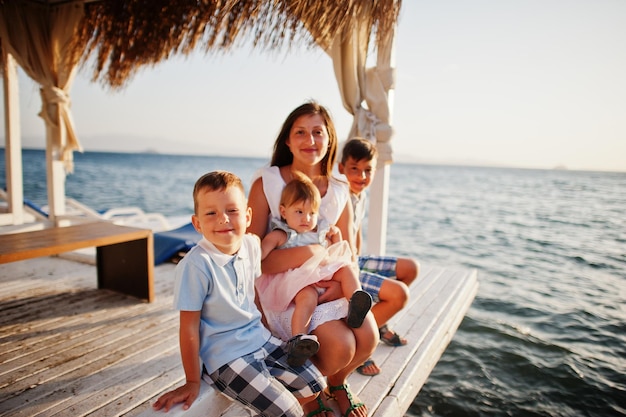 Madre con tre bambini in turchia resort bungalow seduto contro il mar mediterraneo