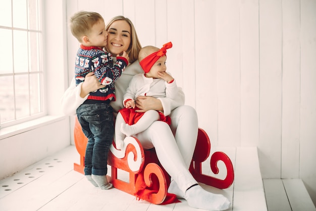 Mother with two children sitting in a sled