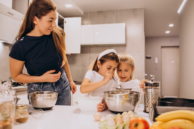 Mother with two daughters at kitchen baking