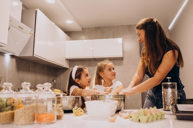 Mother with two daughters at kitchen baking