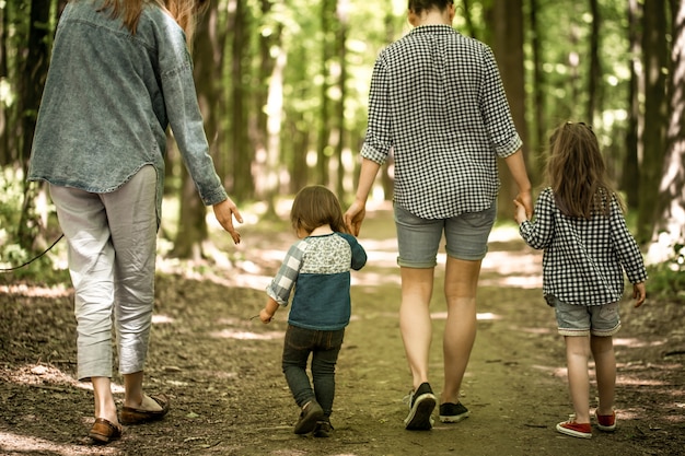 Free photo mother with young daughters walk in the woods