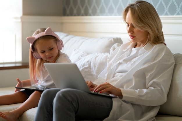 Foto gratuita madre che lavora da casa cercando di conciliare la vita familiare con il bambino e il lavoro