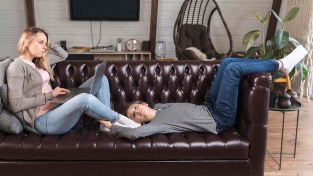 Mother working from home with son next to her