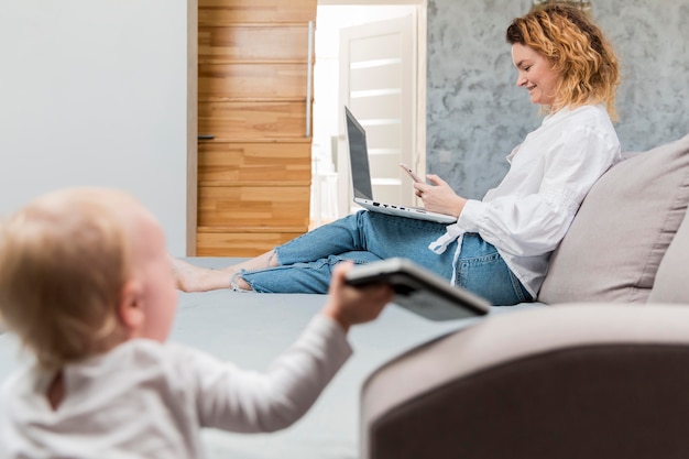 Foto gratuita madre che lavora al computer portatile