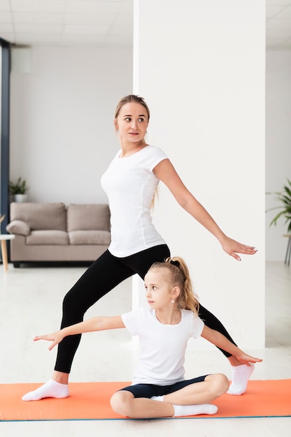 Mother working out at home with daughter