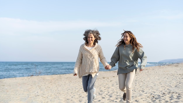 Free photo mother and young daughter spending time at the beach together