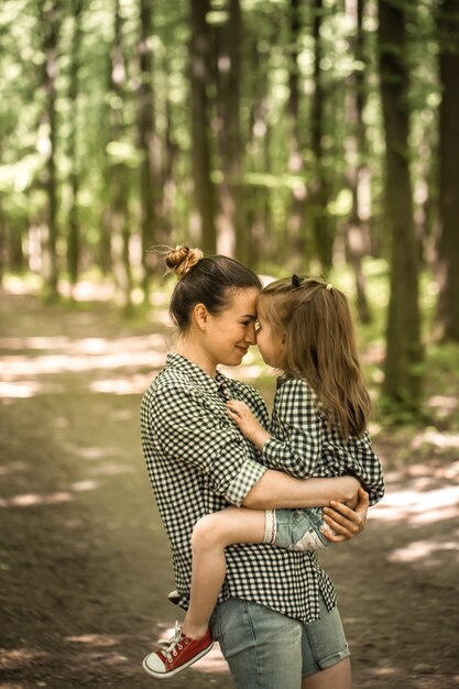 Mother and young daughter walk in the woods