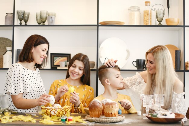 Madri e bambini che dipingono le uova di pasqua.