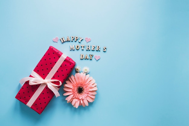 Free photo mothers day composition with flower and red present box