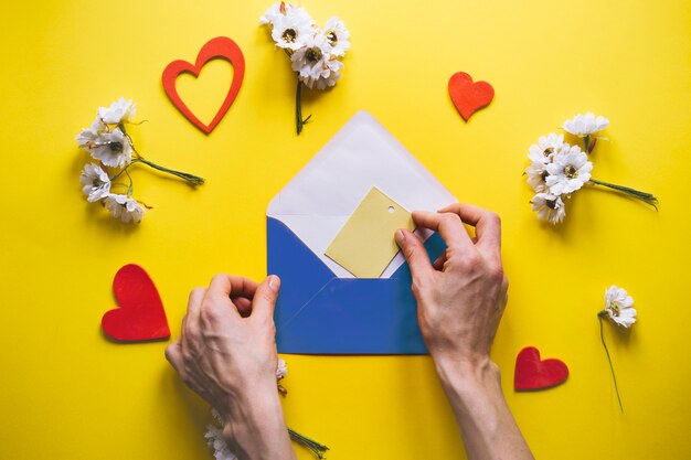 Mothers day composition with hands placing card in envelope