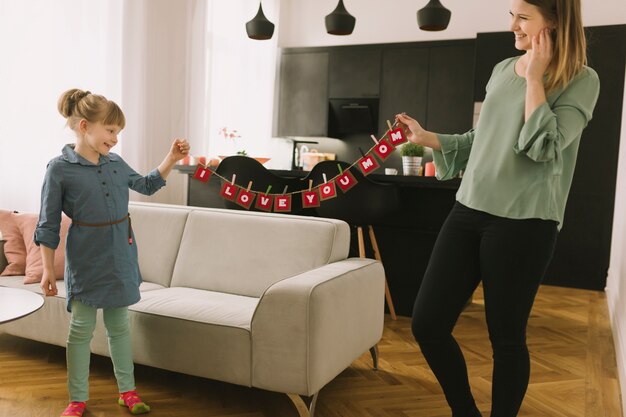 mothers day concept with mother and daughter in living room