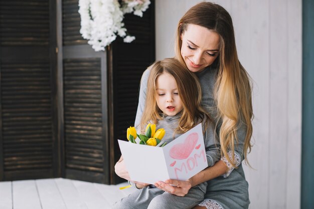 Mothers day concept with mother and daughter reading card