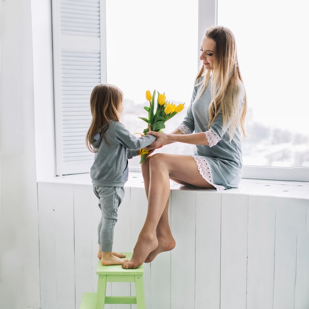 Mothers day concept with mother and daughter with yellow flowers