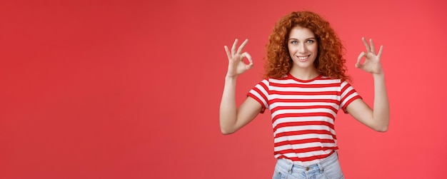 Motivata ambiziosa giovane ragazza riccia dai capelli rossi di bell'aspetto autorizzata che assicura tutto ciò che è eccellente