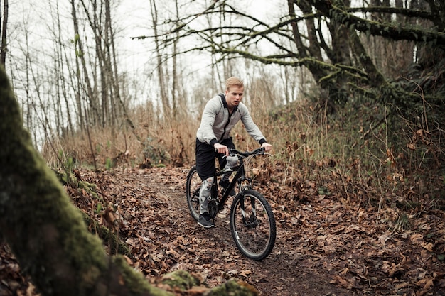 숲의 흔적에 스포츠 자전거를 타고 산악 자전거