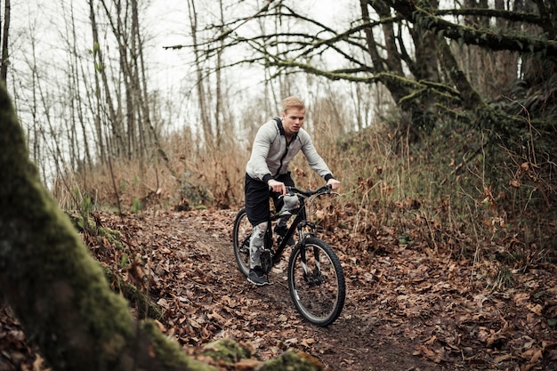 Mountain biker riding on sport bike on forest trail